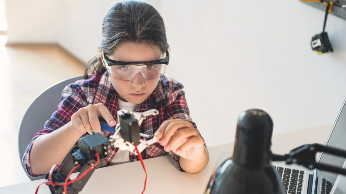 Meisje schroeft aan een robot