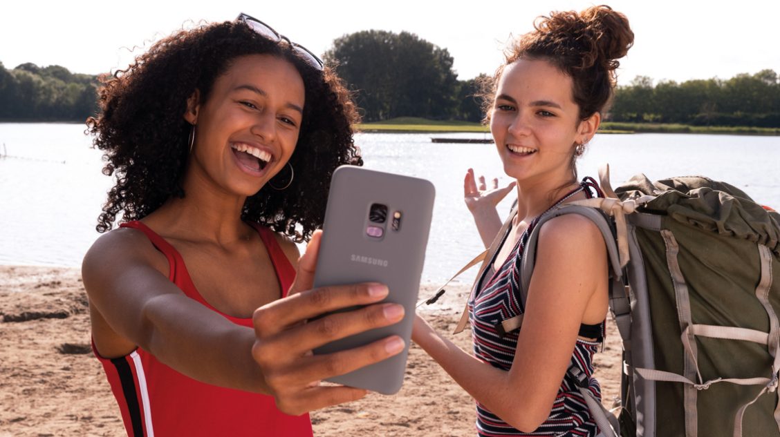 twee personen maken een selfie bij het water