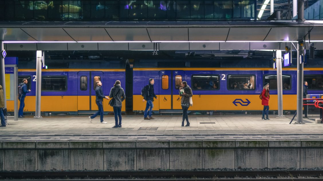 meerdere mensen staan te wachten op de trein