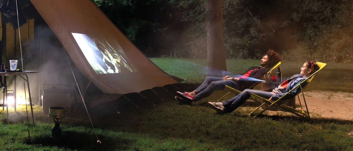 2 mensen kijken een film op de camping