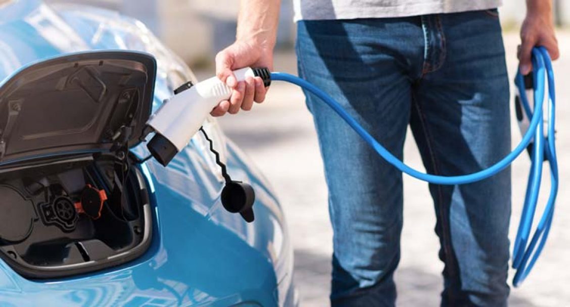 Man laadt elektrische auto op met kabel